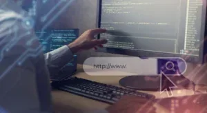 Pessoa aponta para tela com códigos de programação e uma barra de busca sobreposta com o texto "http://www. ".